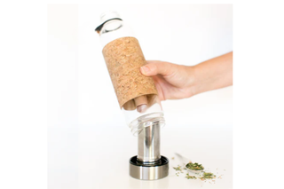 Cork stopper being used on a bottle with a hand holding it, on a white background