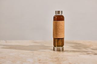 Bottle with cork sleeve on a marble surface